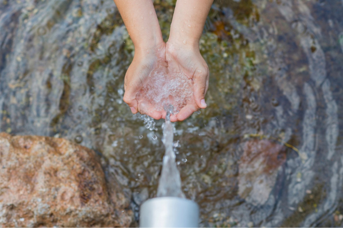 unas manos recogiendo agua de una fuente