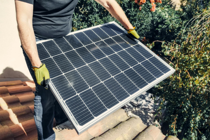 una persona cargando un panel solar