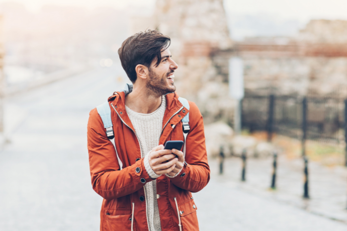 un joven en una ciudad mirando el móvil