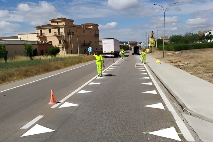 una carretera con señalización de dientes de dragón en el firme para reducir la velocidad