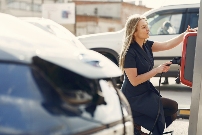 una mujer recargando un coche eléctrico