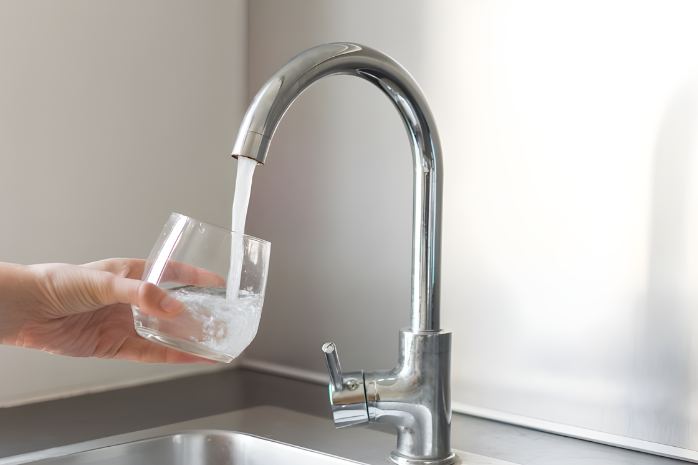 un grifo llenando un vaso de agua