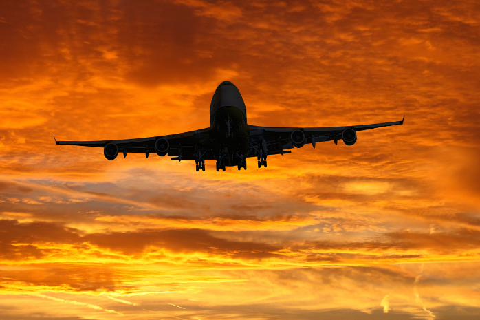 un avión volando en un atardecer