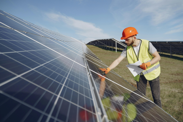 un operario trabajando en una placa solar