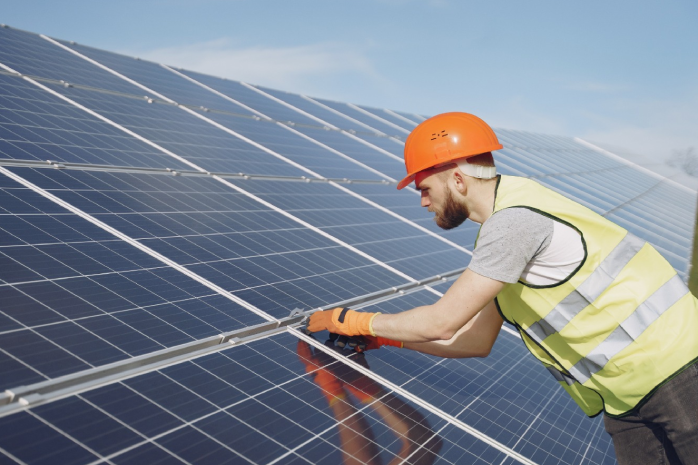 un operario trabajando en un panel solar