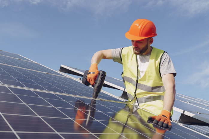 un operario trabajando en un panel solar