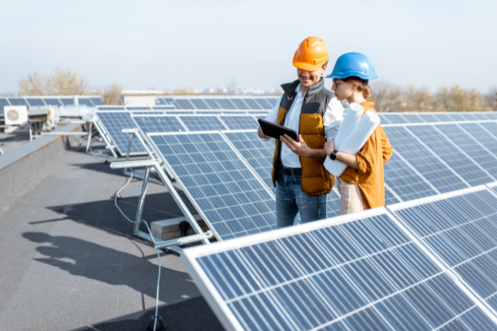 dos operarios de píe una instalación fotovoltaica