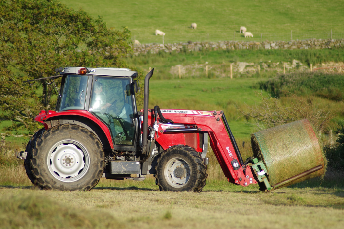 Tractor levantando una paca