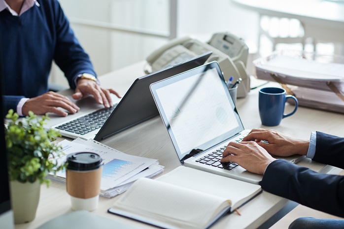 Dos personas trabajando con sus ordenadores portátiles