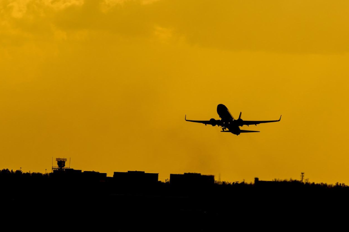 Imagen a contraluz de un avión despegando